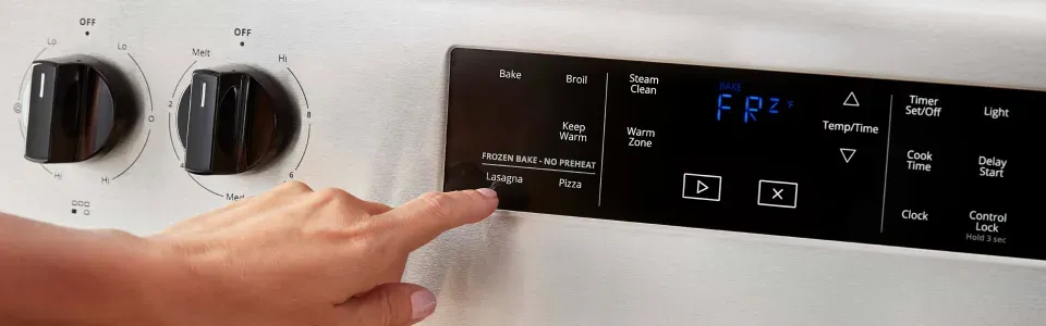 photo of someone pressing buttons on the screen of a whirlpool oven with frozen baken technology